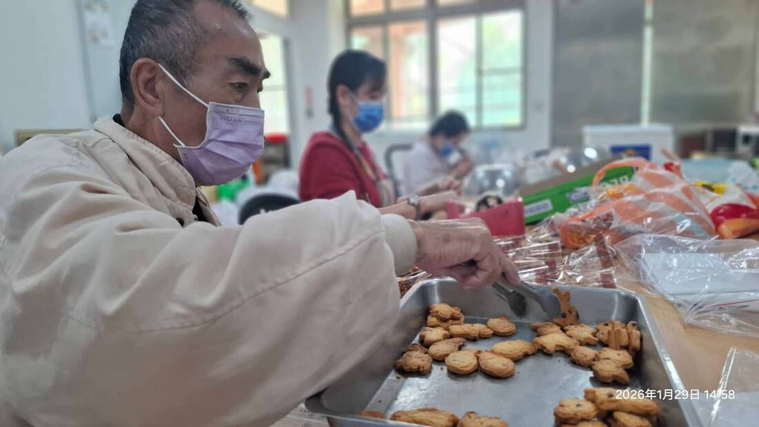 龍崎教養院服務對象細心將剛出爐的手工餅乾夾起並進行封裝，展現嚴謹的食品衛生與品質控管。