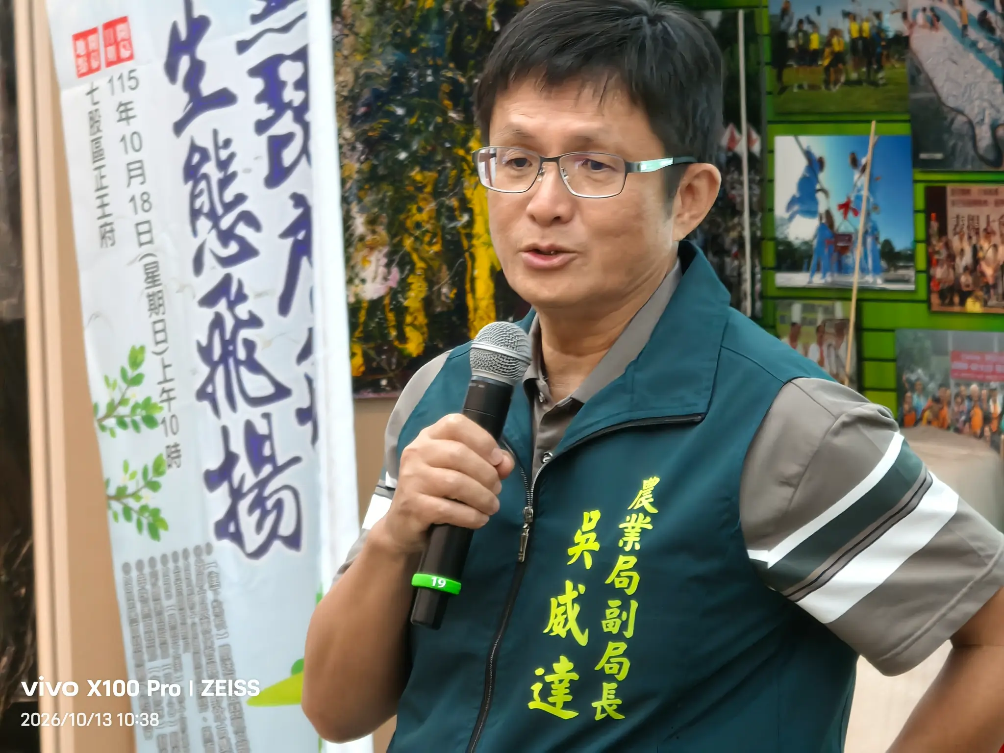臺南市政府農業局副局長吳威達穿著深綠色制服,於黑面琵鷺保育季行前記者會持麥克風發言。