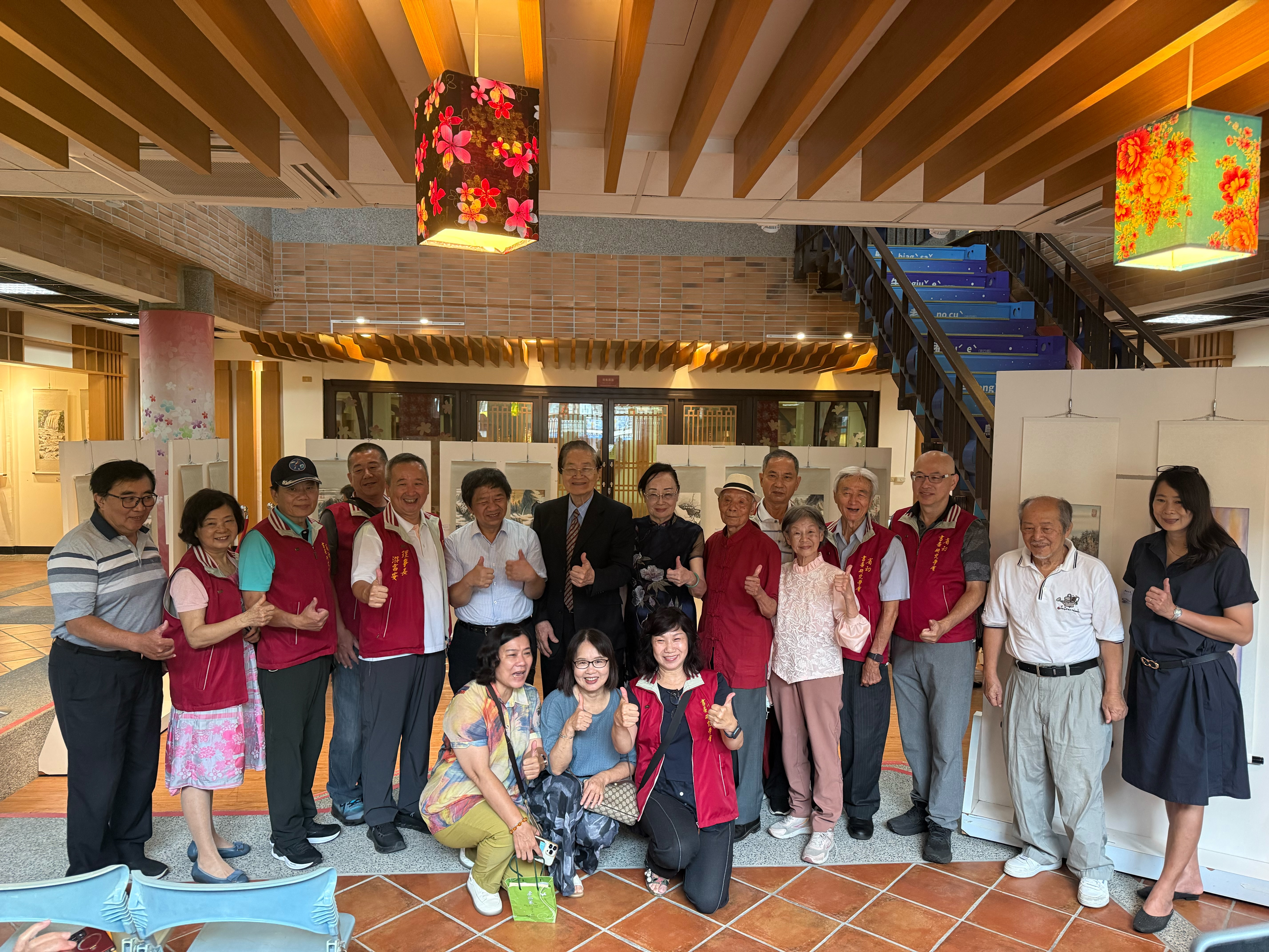 藝文界與會貴賓於水墨作品展示區前合影，為「墨舞丹青」張志強師生聯展開幕活動增添交流氣氛。（圖／臺南市政府客家事務委員會提供）